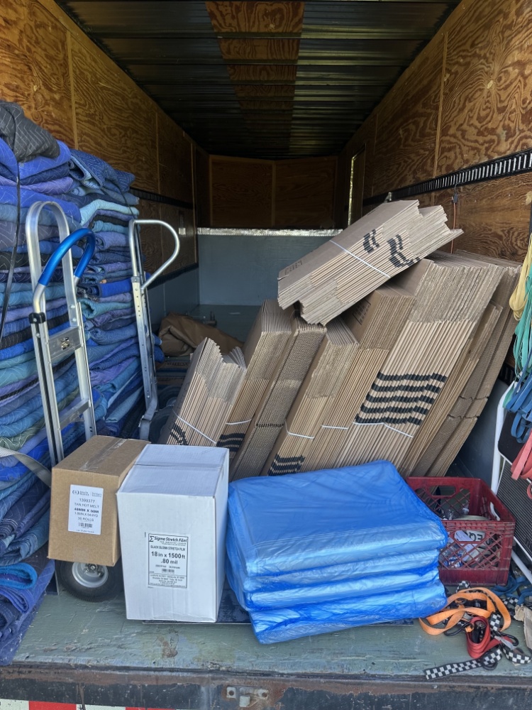 Professional moving truck loaded with blankets, boxes, and supplies